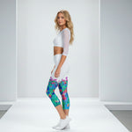 Load image into Gallery viewer, Woman wearing a white athletic top and colorful leggings on a white background
