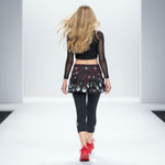 Load image into Gallery viewer, Woman walking on a runway wearing a black outfit with red accents.
