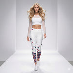 Load image into Gallery viewer, Woman wearing a white outfit with colorful leggings with Roses Poppies and Yellow pickleballs on a gray background
