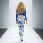 Load image into Gallery viewer, Woman wearing a blue top and patterned leggings on a runway.
