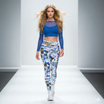 Load image into Gallery viewer, Model walking on a runway wearing a blue top and patterned leggings.
