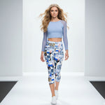 Load image into Gallery viewer, Woman wearing a light blue top and patterned leggings on a runway.
