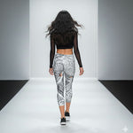Load image into Gallery viewer, Model walking on a runway wearing black crop top and patterned leggings.
