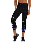 Load image into Gallery viewer, Front view of women's black tennis and padel capris with flowers and tennis balls, denser toward the hem
